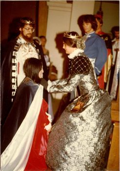 Amsha investing Neptha of Thebes with the Queen's cloak as newly-crowned Martin the Temperate looks on at Coronation on 05/31/1980.
