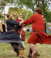 Cameron of Caladoon entertains the populace by tormenting Bruce Draconarius during a lull in Crown Tourney withEvron Beaumaris the Gallowglass as "marshal."