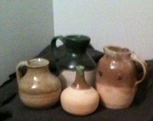A collection of serving jugs. From L to R. A personal sized water or wine jug, a larger serving or storage jug, the narrow jar would have been used in a kitchen, probably for storage of olive oil, a Raspberry jug, known for the raspberries on the shoulders of the serving pitcher.