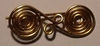 A reproduction double spiral fibula (Greek, seventh century BC) replica in brass after a bronze original in the Louvre Museum.