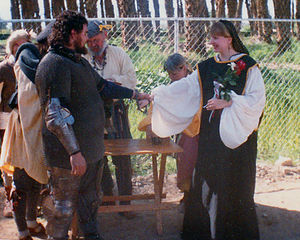 Eadwynne of Runedun and Fionghuala at their handfasting at Crossroads Demo, 1993. Crossbow aimed at Eadwynne is off camera.