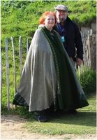 Green Cloak worn by Baroness Morgaine FitzStephen on her recent trip to Ireland. I made it from 100% wool woven on the Isle of Lewis for the movie Rob Roy. Because the fabric was limited, I used a felted dark green down the front and back of the cloak & a plaid "school" kilt [purchased at Salvation Army] that I over-dyed green to match the other fibers. I used trim (purchased from Justina Marie of Burgundy) down the front & a clasp at the neck. Morgaine told me it kept her toasty-warm in the Irish Breezes.