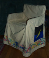 Colm Kyle chair cover: 100% cotton duck base. The devices were appliqué & put on the pockets of the chairs – one on each side. Because they had a doggie, knotted dogs ran around the hem & were painted with thinned acrylic paint (from Home Depot).