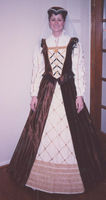 English Elizabethan 1540: This was my first attempt at structured garb Copper colored upholstry fabric for over skirt & bodice. Taffeta was used for the front & on the under skirt. I used mundane rickrack [but it was shiny!] and used the same taffeta for the summer sleeves as on the underskirt. Modeled by Alyse.