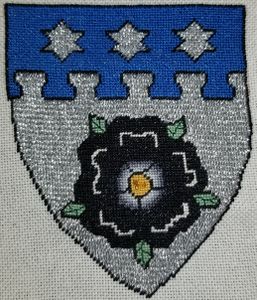 Aliskye Rosel . Argent, a rose sable, barbed and seeded proper, on a chief nebuly azure three mullets of six points argent. Mistress Aliskye was created a Companion of the Order of the Laurel by [[]] on . (Mounting pending)