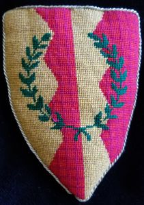 [Barony of Bonwicke] Per pale Or and gules, a pale indented counterchanged, overall a laurel wreath vert. Bonwicke's arms were designed by Giles Hill.