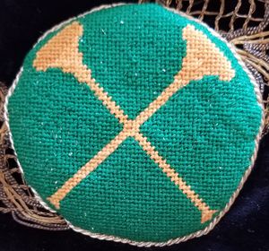Vert, in saltire two trumpets Or. This has been the Heralds' badge since the memory of man runneth not to the contrary, but as far as I can tell, it has never been registered...