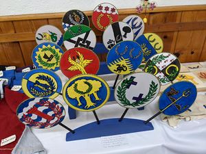 16 dyed and painted silk fans with heraldic devices by THL Amabel Radleigh (Altavia).