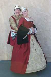 This was the stepping down clothing for Sven and Cassandra from Their second Reign. Her Majesties underskirt was made by Her Majesty however the red silk dress with fur lined sleeves and forepart were made by Ceara. His Majesty's red silk sleeveless Henrecian jerkin and gold silk straight sleeve doublet were also made by Ceara.