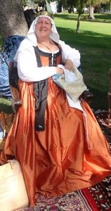 Baroness Ceara Florentine dress in the style of Maddelena Strozzi Doni from 1506. Chemise, gown of rust colored silk with black silk guarding, shoes and veil with coronet. The gown also has detachable blue sleeves, not shown.