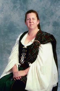 Baroness Ceara An early work from about 2000. An 18th century black Scottish dress with gold lacing rings over a linen leine and an arisaid over her shoulder fastened with a clasp.