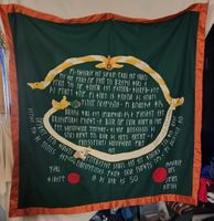 Sir Kettil's Knighting Scroll. It is an embroidered Norse inspired cloak. Designed based on a Rune stone. With the help of Mistress Mary, I was able to ensure proper heraldic wording and stamps. His Excellency Athanric did embroider part of his signature.