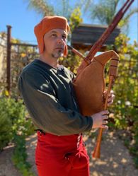 Mons (lovingly with bagpipe) in 16th century Flemish garb, 2023 (knitted cap by Sally Pointer) (photo by Ann Hartl)