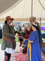 Beorn receiving a basket of largesse from TRMs Wilhelm and Lorissa, Unbelted Tournament, Gyldenholt, 2026. Photo by Wiat the Odd